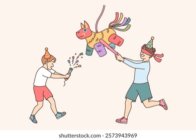 Boy hits pinata with candies during party dedicated to birthday or children entertainment event. Multi-colored pinata in shape of pony, for fun competitions that will improve mood of children