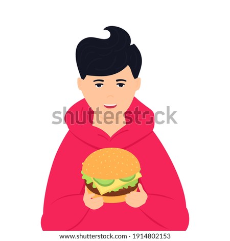 The boy is holding a huge burger. No diet day. Street fast food. Unhealthy eating