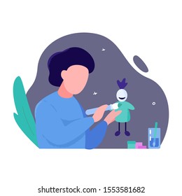 The boy holds a brush in his hands and paints a doll. The concept of creative workshops for children. Creativity development. DIY