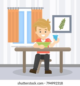 Boy at home sitting at the table with plate and glass.