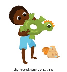 The boy inflates a rubber circle for swimming. The child is wearing shorts. Near the boy is a sand castle and a bucket. Cartoon illustration isolated on white background.