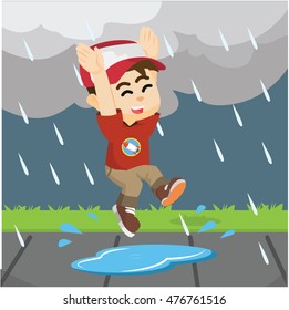 boy jumping in rain on a puddle