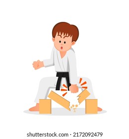 boy in a karate suit breaks a block with his hands