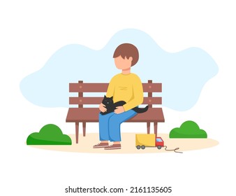 A boy with a kitten on a park bench