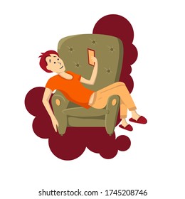 The boy lies through a chair with a phone in his hand.