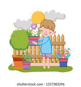 boy lifting houseplant with fence in the garden
