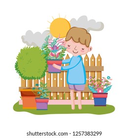 boy lifting houseplant with fence in the garden
