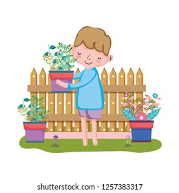 boy lifting houseplant with fence in the garden