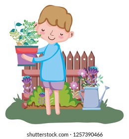 boy lifting houseplant with fence and sprinkler