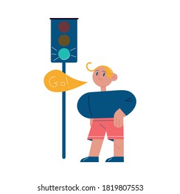 Boy looking at green permitting traffic light and memorizing traffic rule sign to go