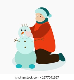 A boy makes a snowman out of snow
