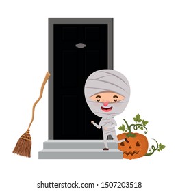 boy with mummy costume and pumpkin in house door