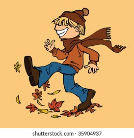 Boy playing with fallen leaves in autumn