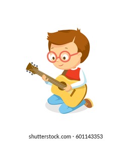 Boy playing guitar. Boy plays an acoustic guitar. Learning to play acoustic guitar for children.