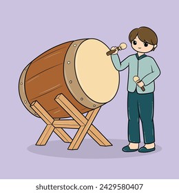 boy playing a large traditional drum with sticks