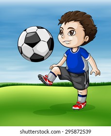 Boy playing soccer in the green field
