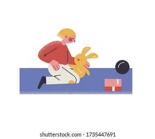 Boy playing with toy rabbit on floor at home during coronavirus pandemic