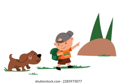 A boy with a puppy and a backpack go hiking up the mountain in the forest. The boy is talking to the dog, showing the direction with his hand.