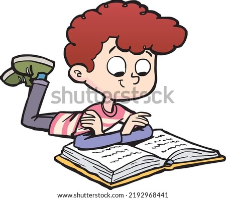 boy is reading a book lying on his stomach