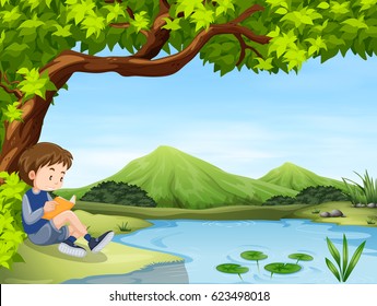 Boy reading by a pond