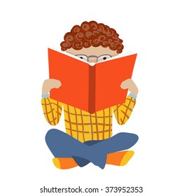 Boy reading, sitting with crossed legs and hiding behind a book.