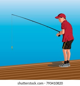 Boy in the red shirt and black shorts is sitting on the dock with a fishing rod. Fishing from the pier into the sea or a river shore