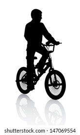 A boy rides a bicycle on a walk. 