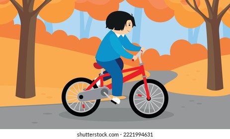 boy riding a bike in autumn park
