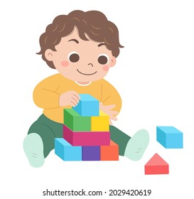 The boy sits on the ground and pushes the blocks, holding the blocks in his hand to pile them up.