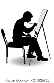 boy sitting at his easel and paints on canvas 