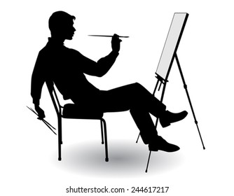 boy sitting at his easel and paints on canvas 