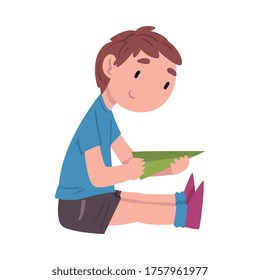 Boy Sitting on the Floor and Playing with Paper Airplane, Cute Child Daily Routine Activity Cartoon Style Vector Illustration on White Background