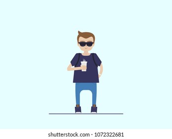 boy in sunglasses holds a glass of coffee in his hand