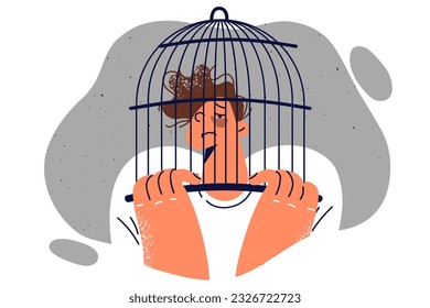 Boy teenager victim of bullying with bruises on face put birdcage on head for concept combating child cruelty. Guy is experiencing psychological problems due to bullying from classmates or friends