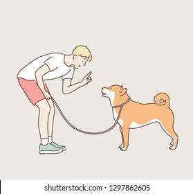 A boy is training a dog. hand drawn style vector design illustrations. 