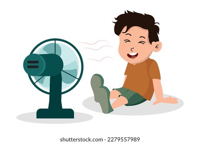 a boy uses a fan to cool his body.