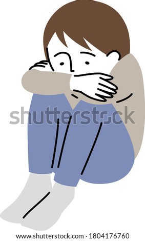 a boy who couches down with a sad expression