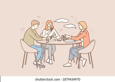 Brainstorming, teamwork, business group concept. Group of young positive business workers sitting at desk, working together reading documents and discussing ideas i office