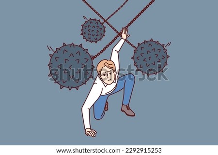 Brave man dodges prickly balls suspended from chain, symbolizing business problems and obstacles to success. Guy demonstrates leadership qualities by overcoming problems and adapting to situation