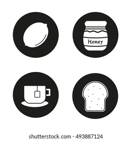 Breakfast items icons set. Lemon, covered honey pot, teacup on plate, toasted bread. Vector white silhouettes illustrations in black circles