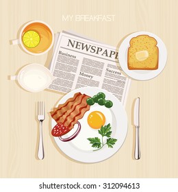 Breakfast set with tea, lemon, milk, bacon and eggs, parsley, toast, butter and newspaper. Top view. Mealtime.