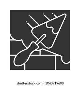 Brick wall with triangular shovel glyph icon. Cement solution. Putty knife, spatula. Silhouette symbol. Negative space. Vector isolated illustration