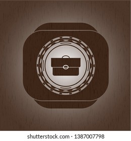 briefcase icon inside wooden emblem. Vintage.