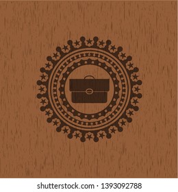 briefcase icon inside wooden emblem
