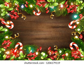Bright christmas decorations with candies leaves and fairy lights on brown wooden background realistic vector illustration