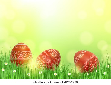 Bright festive background with three red patterned Easter eggs in grass