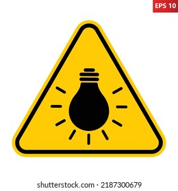 Bright light warning sign. Vector illustration of yellow triangle sign with bulb icon inside. Caution blinding lights. Hazard symbol isolated on background. Glare symbol. Use protective sunglasses.