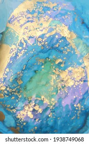 Bright liquid ink, abstract background in gold, blue and purple colours