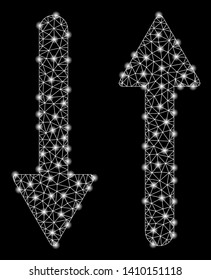 Bright mesh arrows exchange vertical with glare effect. Shiny wire frame polygonal mesh in vector format on a black background. Abstract 2d mesh built from polygonal grid, points, glossy glare spots.