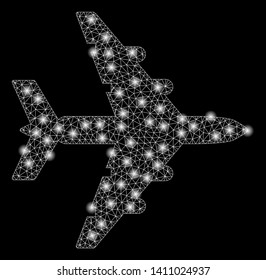 Bright mesh bomber with glare effect. Abstract illuminated model of bomber icon. Shiny wire frame triangular mesh bomber abstraction in vector format on a black background.